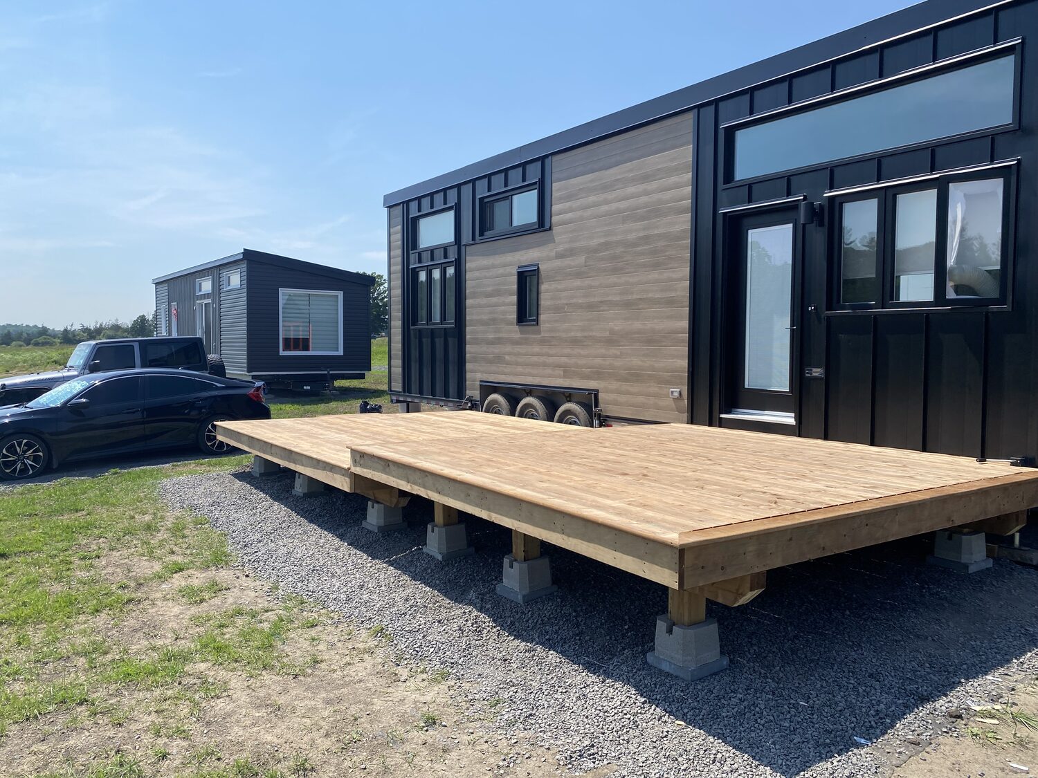 The same deck with its boards laid, standing on posts and footings over gravel.