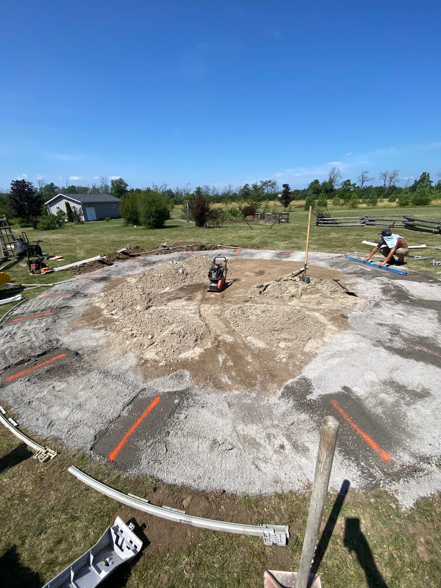 A levelled circle of sand and stone dust for an above-ground pool, with the sod cut back around it.